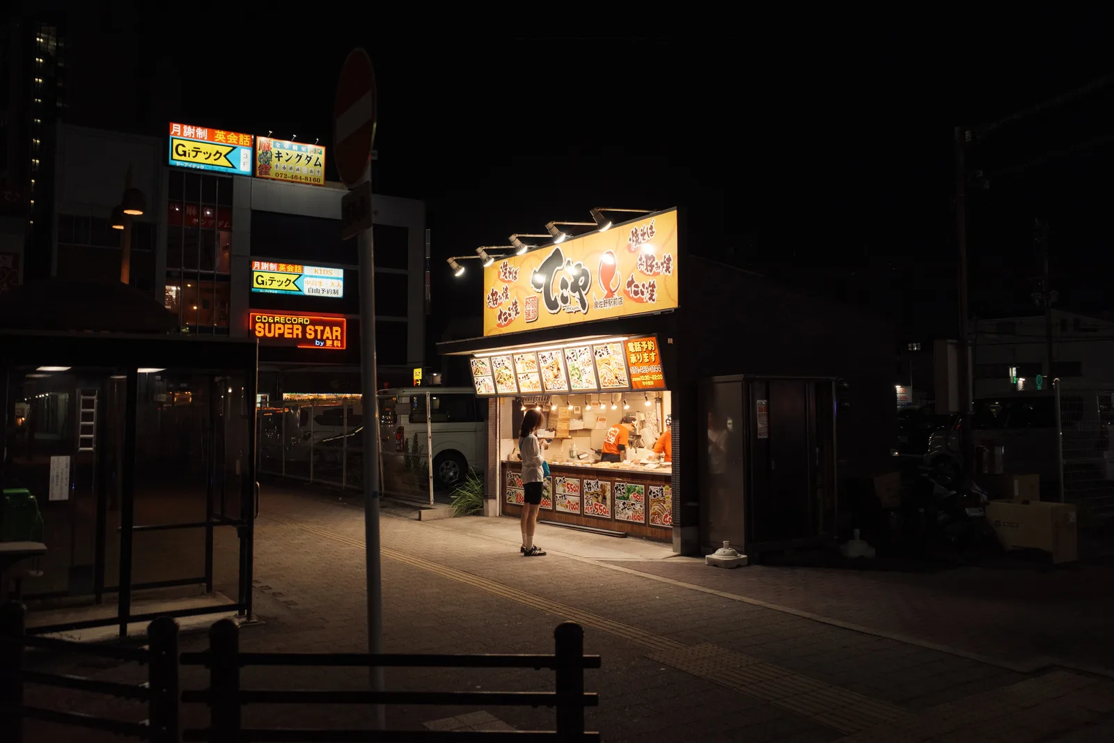 夜色中的街边小店被暖色灯光照亮